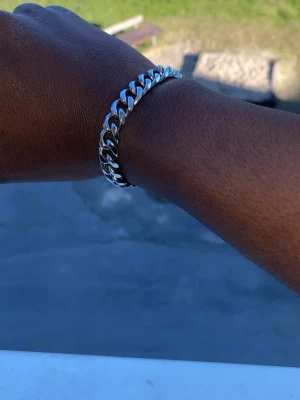 Silverfärgat kedjearmband i stål - Snyggt armband i silverfärgat rostfritt stål med klassisk kedjelänk-design. Armbandet har en stilren och tidlös look som passar perfekt till din vardagsstil. Länkarna är platta och blanka vilket ger en cool och modern känsla.