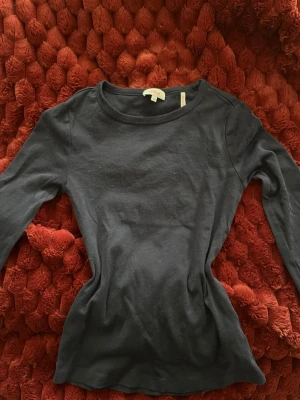 Marinblå långärmad topp - En enkel och stilren marinblå långärmad topp. Rund halsringning och figurnära passform. Perfekt att matcha med jeans eller kjol för en clean look.