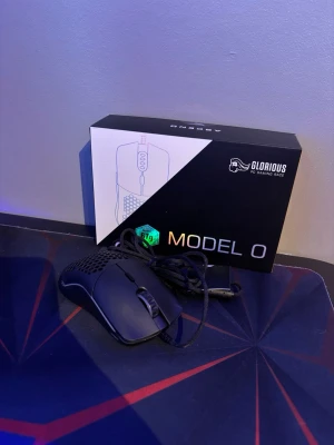 Glorious Model O gamingmus svart - Säljer en svart Glorious Model O gamingmus med honeycomb-design och sladd. Musen är lättviktig och har RGB-belysning, optisk sensor och USB-anslutning. Perfekt för snabba rörelser och gaming. Originalkartong medföljer.