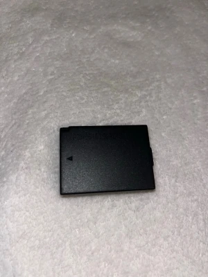 Svart kamerabatteri - Säljer ett svart kamerabatteri med rektangulär form och fyra guldfärgade kontaktpunkter. Perfekt som extra batteri till din kamera. Tillverkat i plast och metall. Till Canon.