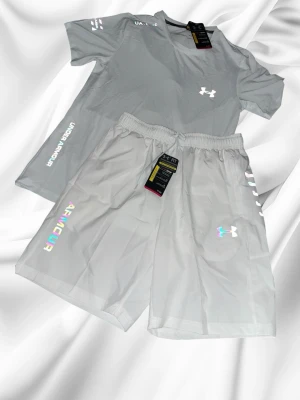 Under armour set - Vit - Riktigt snyggt set från under armour i färgen vit med regnbågs reflektiv som gör den så snygg. Storlek M. Aldrig använd. Rekommenderar starkt att köpa. OBS!! Köp inom 48 timmar få 149kr rabatt!!