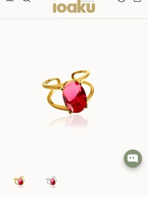 Guldfärgad ring med rosa sten från Ioaku - Unik guldfärgad ring från Ioaku med en stor oval rosa sten i mitten. Ringen har en öppen design med dubbla band som ger en modern och trendig look. Perfekt statement piece för dig som vill sticka ut.