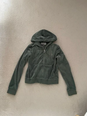 Juicy Couture set - Grönt set från Juicy Couture. Använt ett fåtal gånger, men tyvärr tappt metallpiggarna vid snörerna, därav priset. Storlek S i byxor & M i tröja. 
