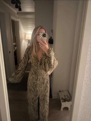 Adoore klänning  - Superfin långklänning med zebramönster, knappar och v-ringning. Klänningen är i nyskick, endast testad💞 Hör gärna av er vid mer frågor💕