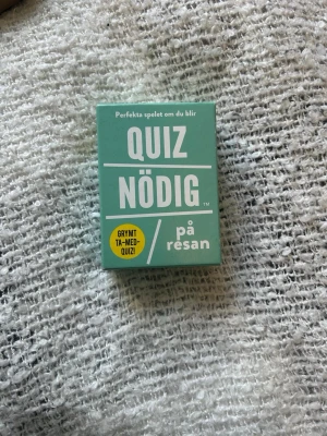 Quiznödig på resan frågespel - Quiznödig på resan är ett litet och smidigt frågespel i grön ask från Kylskåpspoesi. Spelet innehåller över 200 roliga och lättsamma frågor med humor, perfekt för att utmana vänner och familj. Asken är rektangulär och tillverkad i kartong. Förpackningen har lite defekter men korten är som nya
