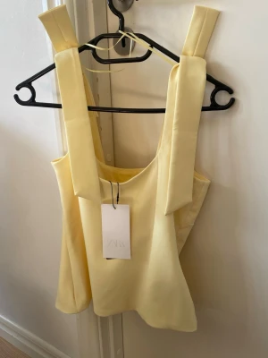 Gul Zara topp - Supersöt ljusgul topp från Zara som aldrig är använd. Säljer pågrund av att den är förstor för mig.💗