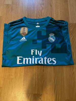 Real madrid tröja Ronaldo 2017 borta tröja blå - En blö fotbollströja borta real Madrid 2017 med en unik fotbollspelare på ryggen vid namn Ronaldo, en fin tröja som är helt i ny skick utan prislapp. Har aldrig användts, storlek S. Detta är en champions league tröja som real Madrid hade 2017 som även Ronaldo hade, de hade 12 champions league titlar då