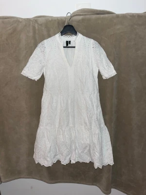 Vit spetsklänning med v-ringning - Säljer en söt vit kortklänning med v-ringning och broderade spetsdetaljer. Klänningen har korta ärmar, volangkant nedtill och ett luftigt, romantiskt uttryck. Perfekt för sommarens alla tillfällen! Har använts 1 gång på konfirmationen! En perfekt klänning för dej! Köpt för 800 så säljer nu för endast 550 kr!!!