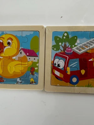 Barn  träpussel  - Säljer fyra färgglada träpussel med motiv av anka, brandbil, panda och nyckelpiga. Pusselbitarna är stora och enkla att hantera, perfekta för yngre barn. Motiven är tecknade och har glada färger. Ramarna är i ljust trä. 79kr /2st / bild 