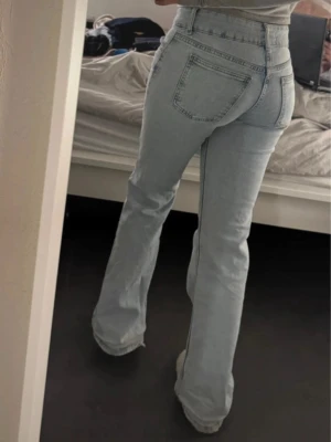 Ljusblå bootcut jeans från Pull&Bear - Säljer ett par ljusblåa lågmidjade bootcut jeans från Pull & Bear i storlek 32 men passar även 34. Använda endast fåtal gånger. Två knappar framifrån som ger en extra detalj. Säljer pågrund av för små för mig men annars drömjeansen. Smutsiga nerifrån men försvinner i tvätten.