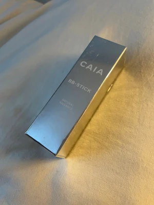 CAIA BB-Stick 50c  - Säljer en CAIA BB-Stick i färgen 50C. Kommer i en snygg, silverfärgad förpackning som känns lyxig och modern. Perfekt för dig som vill ha en smidig bronzer i stickformat för enkel applicering.