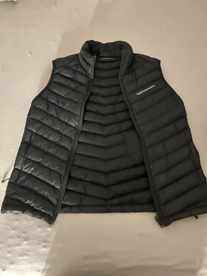 Svart väst från Peak Performance - Har några små hål och är ganska använd, Priset går att diskutera