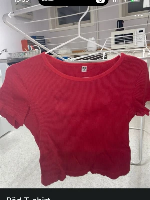 Röd ribbad t-shirt - Säljer en röd ribbad t-shirt med korta ärmar och rund hals. T-shirten har en figurnära passform och är tillverkad i ett mjukt bomullsmaterial. Perfekt till jeans eller kjol för en enkel och snygg look.