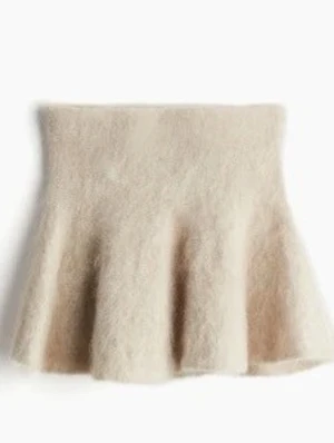 Beige fluffig kjol med volang - Supersöt beige kjol med volangkant och fluffig textur. Kjolen har en hög midja och är tillverkad i ett mjukt material som ger en mysig känsla. Perfekt för dig som vill ha en unik och trendig look.