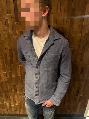 Blå dobber overshirt  - Snygg blå overshirt i mjukt tyg med två bröstfickor och knappar framtill. Märke: Dobber! Skick: 9/10🔥! Storlek: M! Modellen är 180 cm och väger 70kg. Hör av er vid frågor! Pris går att diskutera!