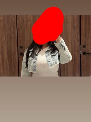 Ljusblå croppad jeansjacka - Trendig ljusblå croppad jeansjacka med klassisk krage och knappstängning framtill. Jackan har en avslappnad passform och är perfekt för att lyfta vilken outfit som helst. Snygga sömdetaljer och tidlös denimlook.