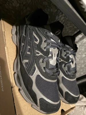 Asics Gel NYC Graphite Grey  - Snygga sneakers i mycket fint skick. Endast lätt använda ca 2-3 ggr och fortfarande otroligt fräscha både i material och form. Inga  tecken på slitage perfekta för dig som vill ha ett par stilrena skor till ett bra pris. (KVITTO FINNS)!!