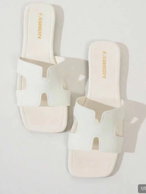 Vita slip-in sandaler med öppen tå - Stilrena vita sandaler från Fashion med öppen tå och breda remmar i syntetmaterial. Modellen har fyrkantig tå och slip-in design, aldrig använda