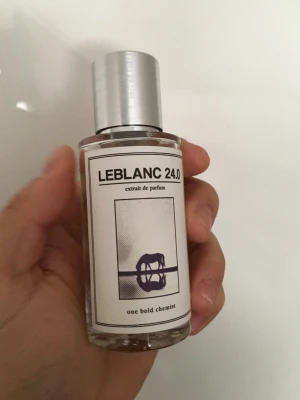 LEBLANC 24.0 Extrait de Parfum - Parfymflaska från one bold chemist med namnet LEBLANC 24.0. Flaskan är genomskinlig med en stilren vit etikett och ett modernt grafiskt tryck i blått. Locket är i borstat silverfärgat metall. Innehåller bland annat linalool, limonene och hexyl cinnamal.