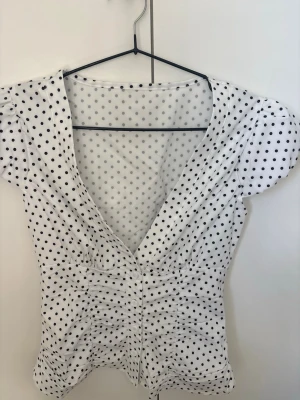 Vit prickig blus  - Supersöt vit blus med svarta prickar och v-ringning. I storlek XS men funkar som S också💕Aldrig använt!