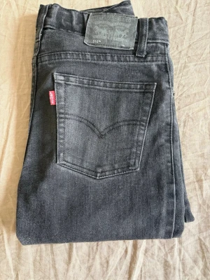 Levi's 510 Skinny svarta jeans 14A (barn)  - Svarta skinny jeans från Levi's modell 510. Klassisk femficksdesign med Levi's röda logga på bakfickan och patch bak i midjan. Jeansen har smal passform och är tillverkade i stretchigt denimtyg. Dragsko i midjan för olika storlekar. 