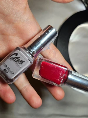 Nagellack Glam of Sweden röd & grå - Två nagellack från Glam of Sweden, ett i klassiskt röd färg och ett i trendigt ljusgrått. Båda har silvriga lock och kommer i fyrkantiga glasflaskor på 8 ml. Perfekta för att skapa snygga nagellooks hemma.
