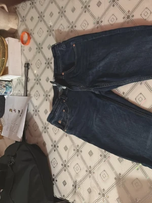 Mörkblå bootcut jeans - Snygga mörkblå bootcut jeans med klassisk femficksdesign och dragkedjegylf. Jeansen har en något utsvängd passform nertill och är tillverkade i denim. Perfekta för en avslappnad och trendig look.