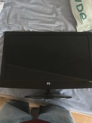 Svart HP datorskärm - Säljer en stilren svart datorskärm från HP med bred ram och stabil fot. Perfekt för dig som vill ha extra skärmyta till datorn. Skärmen har en klassisk rektangulär form och passar bra på skrivbordet.