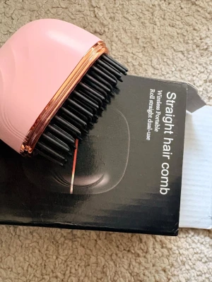 Rosa elektrisk värme hår borste - Snygg rosa elektrisk hårkam med svarta borst och detaljer i roséguld. Perfekt för att räta ut håret snabbt och smidigt. Kommer med skyddande lock och är enkel att ta med i väskan. Passar dig som vill ha slätt hår utan krångel.