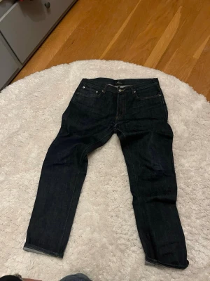 RAW SELVEDGE JEANS FRÅN APC - Snygga mörkblå jeans från APC i klassisk femficksmodell. Jeansen har raka ben och är tillverkade i ett robust denimtyg. Perfekta för dig som gillar en tidlös och stilren look.