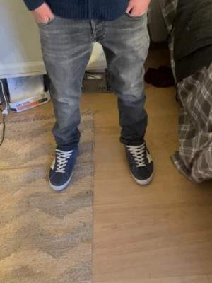 Grå slim fit jeans med tvättad look - Snygga grå slim fit jeans med tvättad och något sliten look. Jeansen har klassisk femficksdesign och smal passform som sitter bra längs benen. Perfekta för en avslappnad och trendig stil.