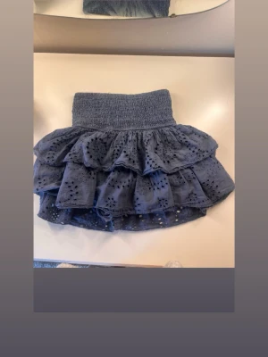 Blå volangkjol från meet x Tiger - Supersöt blå kjol från meet me there x Tiger med bred smock i midjan och flera lager volanger. Kjolen har broderade detaljer. Det är undershorts! Storlek S/M jag har ofta S och den passar💓💓