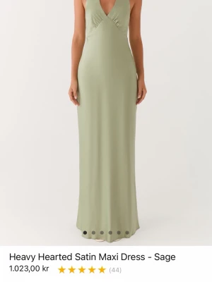 Ljusgrön långklänning med öppen rygg - Snygg ljusgrön långklänning med halterneck och öppen rygg. Klänningen har knyt i nacken och en elegant, figurnära passform. Perfekt för sommarens tillfällen när du vill sticka ut med en stilren look.