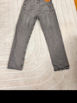 Grå jeans från Jack & Jones - Snygga grå jeans från Jack & Jones i klassisk femficksmodell. Jeansen har rak passform och är tillverkade i denim med en lätt tvättad look. Perfekta för dig som gillar en avslappnad och stilren stil.