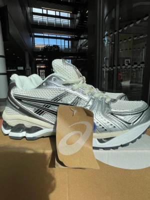 Asics gel kayano 14  - Snygga sneakers från Asics i silver och vitt med svarta detaljer. Jag köpte dem här skorna från Asics nyligen och jag säljer dem för att dem inte passar mig. Dem har använts lite och den ser mycket bra ut från utsidan och i insidan så har texten gått bort lite.