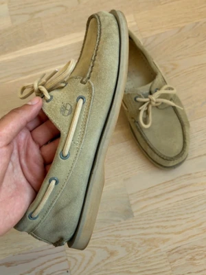 Seglarskor Timberland  - Snygga beige seglarskor i mocka från Timberland med klassisk snörning och detaljer i ljusbeige. Skorna har rundad tå, Timberland-logga på sidan. Perfekta för en avslappnad och stilren look.