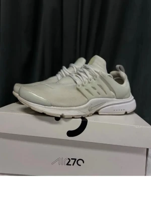 Nike Air Presto vita sneakers - Stilrena Nike Air Presto sneakers i helvitt med mesh- och syntetmaterial. Skorna har en låg silhuett, vita snören och en bekväm, dämpad sula. Perfekta för dig som gillar minimalistisk och sportig stil.
