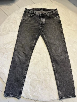 Svarta slim fit jeans med tvättad look - Säljer ett par jättesnygga gråsvarta jeans från Neuw i modellen Ray Straight. Storleken är 31/32. De är i nyskick då de bara är använda ett fåtal gånger. Klassisk 5-ficksmodell med Neuws snygga detaljer på bakfickorna. Skickas snabbt, hör av dig om du undrar över något.