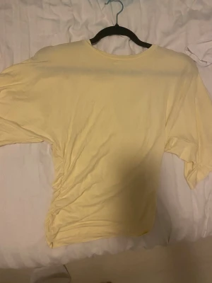 Ljusgul t-shirt från Stories XS - Säljer en ljusgul t-shirt från Stories i storlek XS. T-shirten har rund halsringning och korta ärmar. Tillverkad i mjuk bomull, perfekt för en avslappnad och enkel stil.