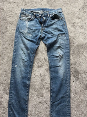 Blå slitna jeans  - Säljer ett par blåa jeans med sliten stil från italienska märket nine:in:the:morning. Börjar bli lite slitna i skrev