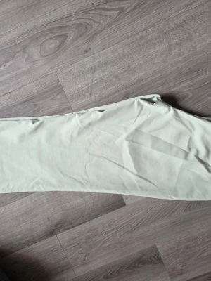 Ljusgröna raka byxor från YAS - Säljer ett par ljusgröna finbyxor med vida ben. Byxorna har minimalistisk design med fickor och är tillverkade i ett tunt, mjukt tyg som ger en clean look. Perfekta för dig som gillar stilrena och enkla plagg. Storlek L