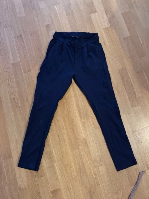 Mörkblå leggings med hög midja - Säljer ett par mörkblå leggings med hög midja och resår i midjan. De har en smal passform och är tillverkade i ett mjukt, stretchigt material som sitter skönt på kroppen. Perfekta till både oversized tröjor och crop tops. Liknande kostymbyxor fast ”mjukis”