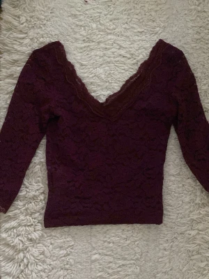 Vinröd spetsblus med v-ringning - Jättefin vinröd spets topp med tre kvarts ärmar. Inga defekter, säljer för att den är fel storlek på mig💞