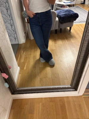 Mörkblå bootcut jeans - Säljer ett par mörkblå bootcut jeans med hög midja och klassisk femficksdesign. Jeansen har en snygg utsvängd passform nedtill och är perfekta för en avslappnad men trendig look. Tillverkade i ett mjukt och stretchigt denimtyg som sitter skönt hela dagen.