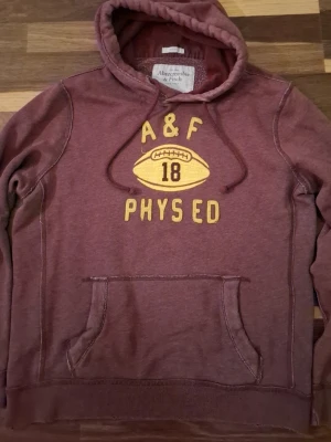 Abercrombie & Fitch Hoodie - Snygg vinröd hoodie från Abercrombie & Fitch! Gammal collection och har väldigt snygga slitningar! Lite urtvättad, men ser fett ut. Pris: 499❗️