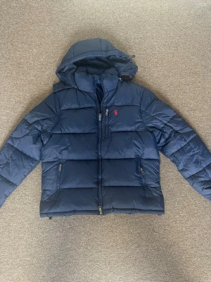 Mörkblå pufferjacka från Polo Ralph Lauren - mörkblå pufferjacka från Ralph lauren. Endast använd 1 gång