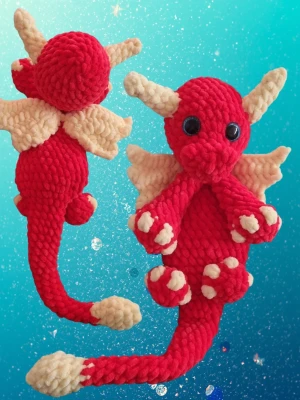 Röd virkad drake med vingar - Handgjord virkad drake i rött sammetsgarn med stora svarta ögon, gula horn, vingar och tassar. Draken har lång svans och detaljerade klor. Perfekt som dekoration eller gosedjur för den som gillar fantasy och drakar. Mkt uppskattad doppresent och babyshower. Jag virkar på beställning där du kan välja egna färger. 