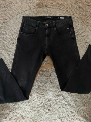 Replay Anbass Jeans - Replay Jeans i modell Anbass  Gråa Jeans i modell Anbass. Mycket fint skick. Storlek: 29/32 (Sitter större i midjan)  Skick: 8/10 inga skavanker såsom hål eller fläckar.    Mått: •Midja: 41cm (stretchar till ≈45cm) •Ytterben: 101cm •Innerben: 77cm  Skriv vid intresse! 