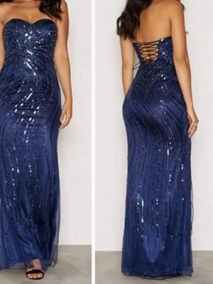 Läs beskrivningen! Festklänning / balklänning.  - Fest-/balklänning i blått från Forever Unique, köpt på Bubbleroom.  Klänningen har använts ett par gånger på bröllop och fester. Om man tittar noga så kan man se att på vissa (små) ställen är pärlorna borta och tylltyget har gått sönder på något ställe. Ta gärna en titt på bilderna! Skickar såklart flera bilder vid önskemål. Klänningen är justerbar och passar som 36-38. Personen på fotot är 1.56, har M storlek och har platta skor på sig.