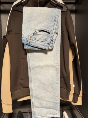 Ljusblå raka jeans i denim - Säljer ett par ljusblå jeans i klassisk rak modell. Jeansen har fem fickor, bälteshällor och är tillverkade i ett mjukt denimtyg. Perfekta för en avslappnad och trendig look. Passar till det mesta och är ett måste i garderoben. OBS!!! Litet hål i byxan som inte är så stor/synlig! Storlek : W29 L30